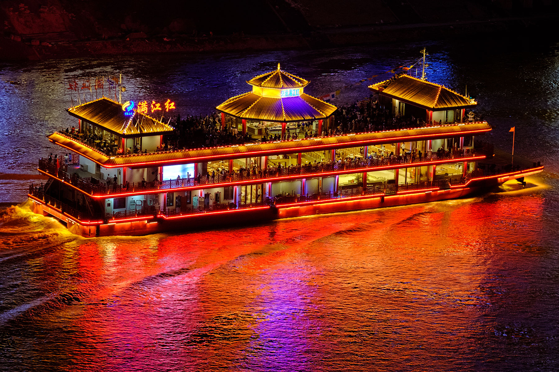 Beleuchtetes Boot auf Fluß bei Nacht in Chongqing